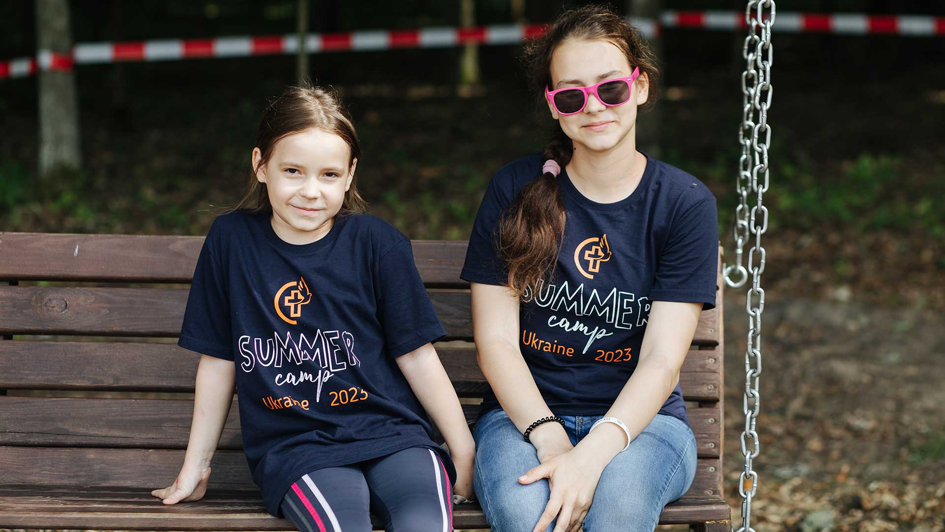 Two girls wearing summer camp t-shirts.